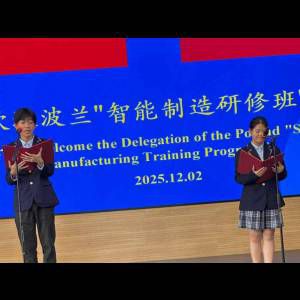 Two students in formal attire read from scripts on stage, welcoming a Polish delegation at an event.