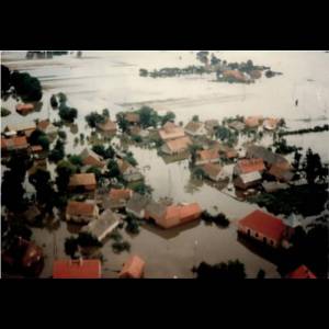 Aerial view of houses submerged in floodwaters, with only rooftops visible amidst the vast waterlogged landscape. Rzeczyca z lotu ptaka/ Fot. H. Graboń