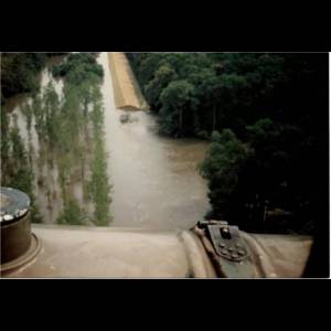 Aerial view of a flooded area with trees and a raised pathway visible amid the water. Wyrwa wałowa na wysokości miejscowości Słup /Fot. H. Graboń