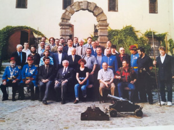 Dziedziniec Arsenału Wrocławskiego, 29 maja 1999 roku. Na zdjęciu widoczny jest profesor Zdzisław Żygulski, prezes Stowarzyszenia Miłośników Dawnej Broni i Barwy. Po jego prawej stronie siedzi Jerzy Zarawski, po lewej Lena Zajączkowska. W tle, w niebieskich mundurach, Wrocławscy Bracia Kurkowi. Po lewej stronie, z bronią drzewcową — tzw. partyzaną — stoi Wojciech Kopacz, obok grupa koleżanek i kolegów ze Stowarzyszenia. Fotografia została zamieszczona w pierwszym wydaniu Encyklopedii Wrocławia.
