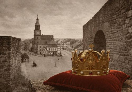 Ilustracja przedstawiająca koronę oraz mur obronny na tle ratusza ze starej pocztówki