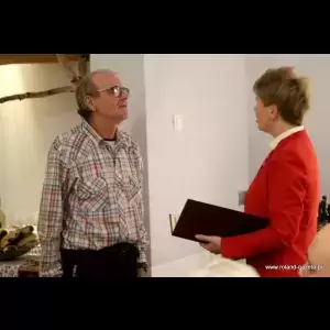 Klubu Honorowych Dawców Krwi „Kropelka Życia” A man in a plaid shirt stands attentively while a woman in a red jacket holds a folder, engaging in conversation.