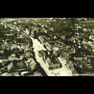 Aerial view of Neumarkt, showcasing roads lined with houses, a church, and surrounding fields. Vintage black and white style.