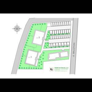 A layout map of a residential area featuring buildings, bike parking, and green spaces near Malczycka Street.